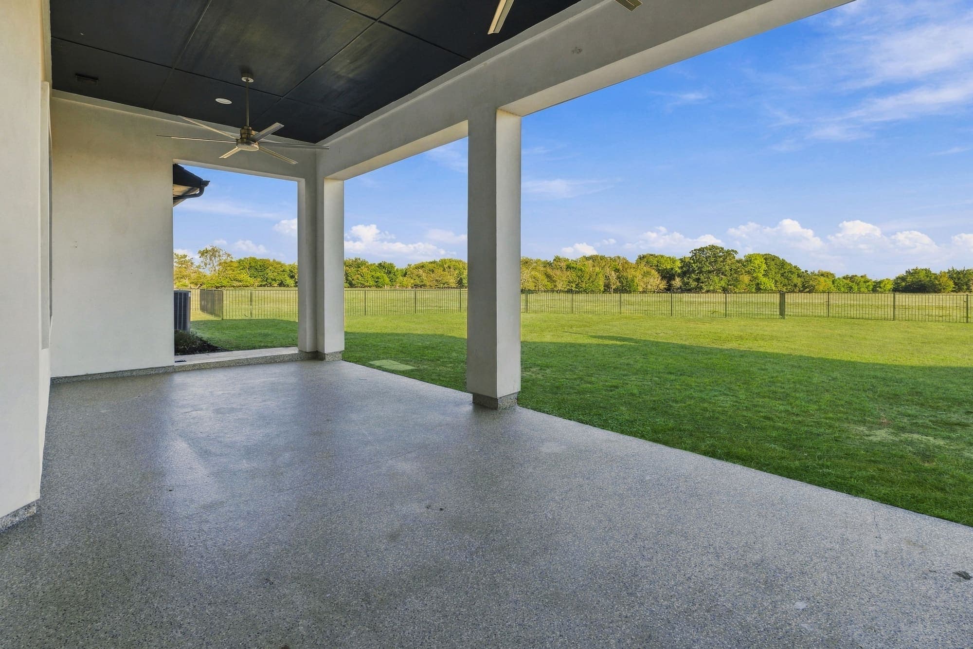 Covered back patio looking out over the lawn and pasture